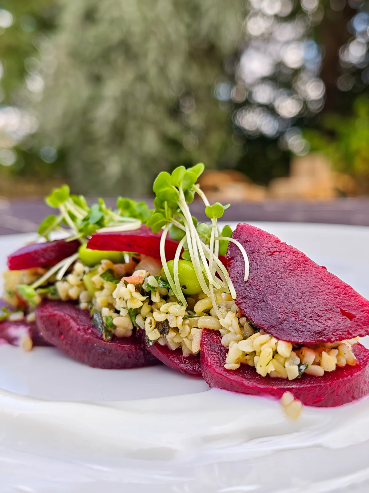 Sliced beetroot layered with a herbed grain salad