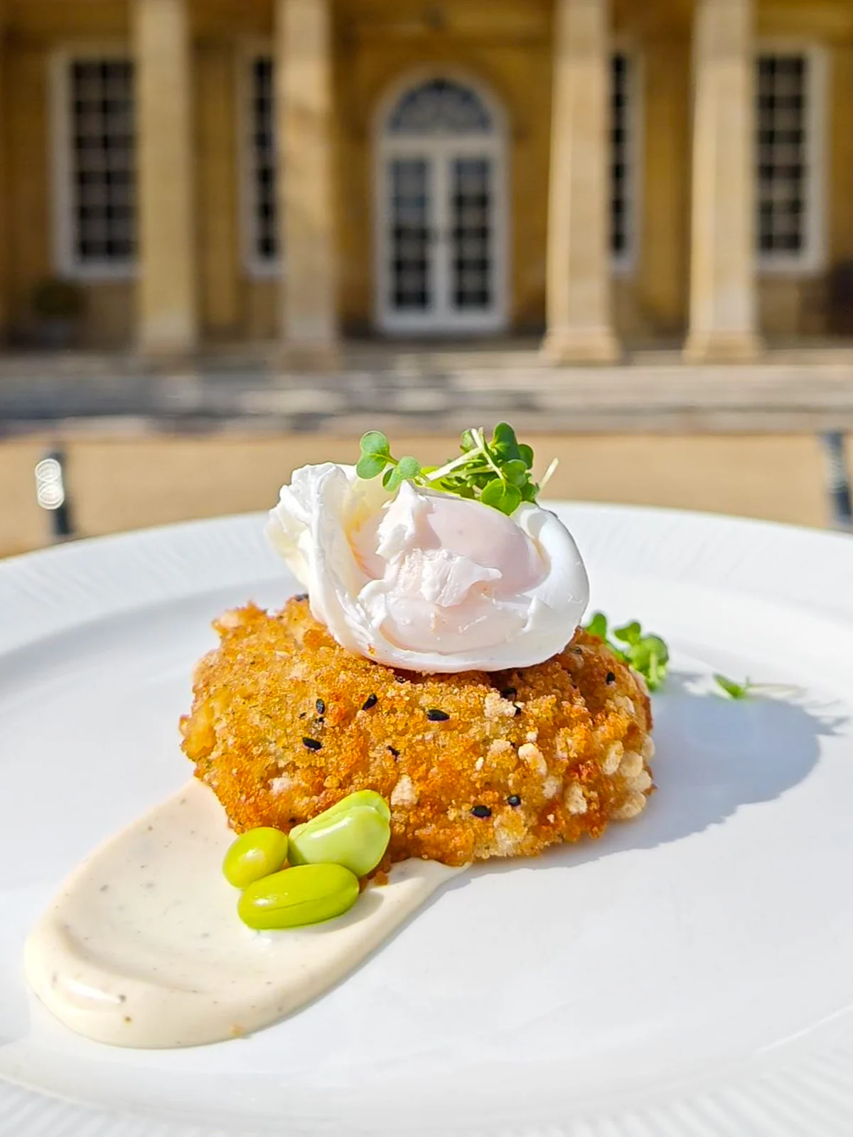 A crumbed cake topped with a soft-poached egg